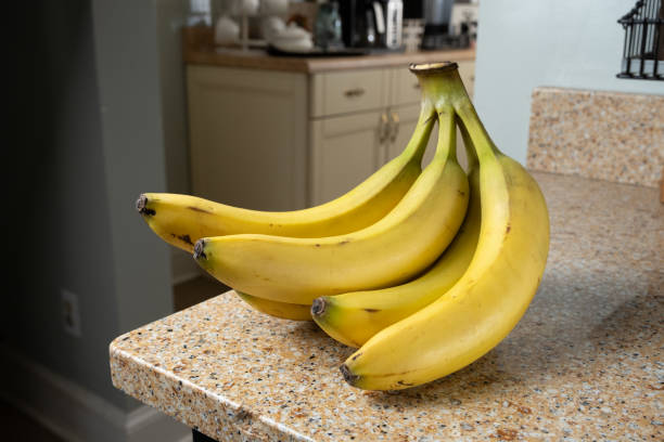 istock Yellow Bananas in a Bunch on Brown Granite Counter 2164206861