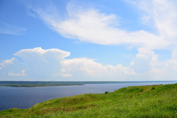istock a green hill with cloudscape over the blue lake copy space 2164212237
