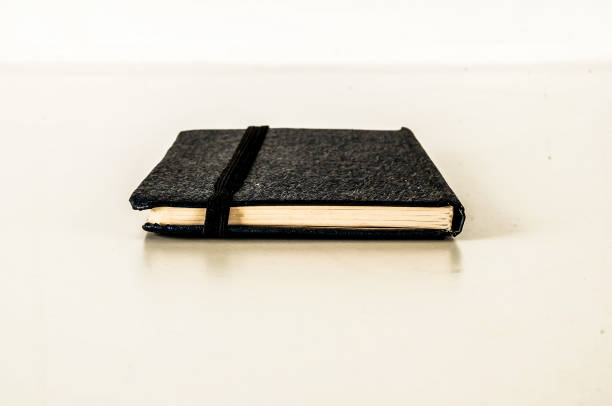 A black leather bound notebook with a black cover and a black spine A black leather bound notebook with a black cover and a black spine. The notebook is open to a blank page old black leather photo album stock pictures, royalty-free photos & images