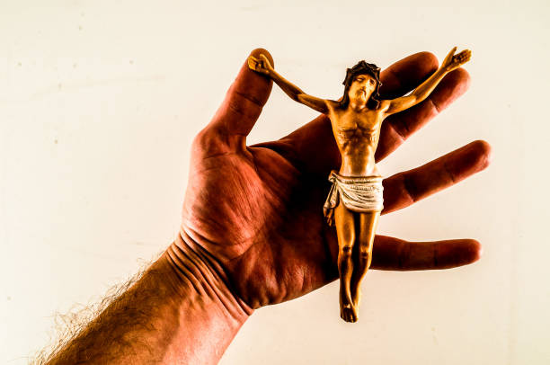 A hand holding a small statue of Jesus Christ. Concept of reverence and respect for the religious figure
