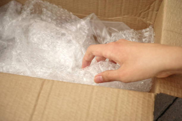 istock A person unboxing a cardboard box with bubble pack inside of it 2164216370
