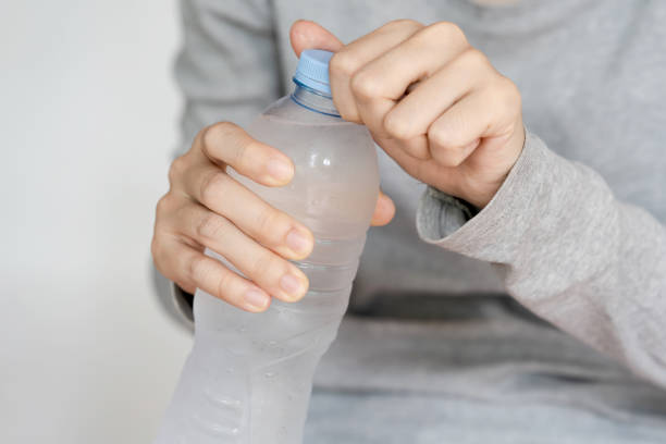 istock A person opening a plastic water bottle, emphasizing hydration and convenience in everyday life. 2164218942