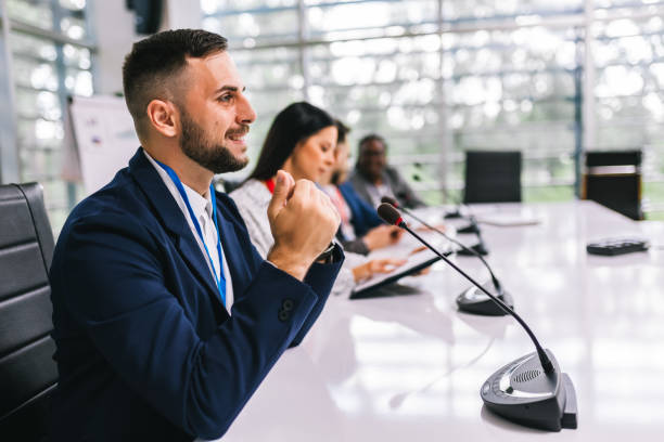 istock Man CEO talking on the microphone on meeting with his colleagues about business plan, future collaboration. 2164221074