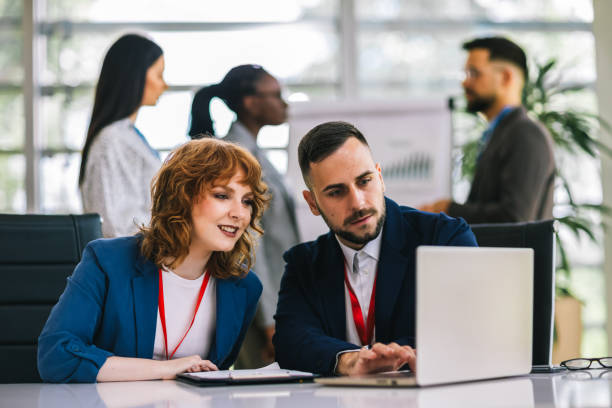 istock Two business people working together on laptops and tablets in office. 2164222451