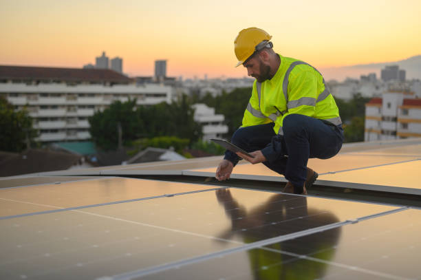 istock Male engineer works installing solar panels on the roof. Engineer or worker working on solar panels or photovoltaic cells on the roof of a business building. 2164223042
