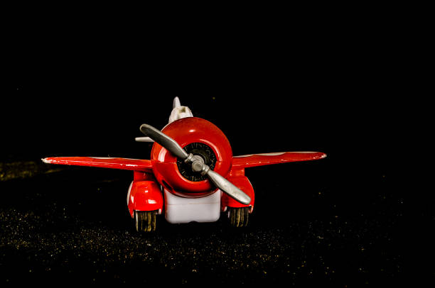 istock A red toy airplane with a white propeller is sitting on a black surface 2164224005