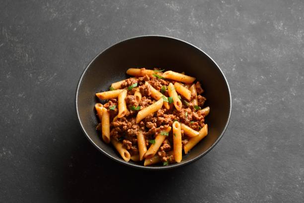 istock Penne pasta with minced meat, tomato sauce and greens 2164224247