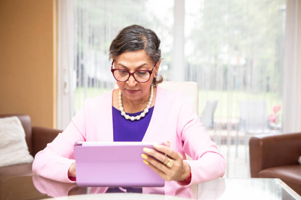 istock Mature woman using a digital tablet at home 2164229046