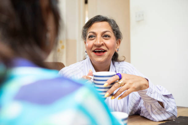 Mature women having a coffee break together in a kitchen