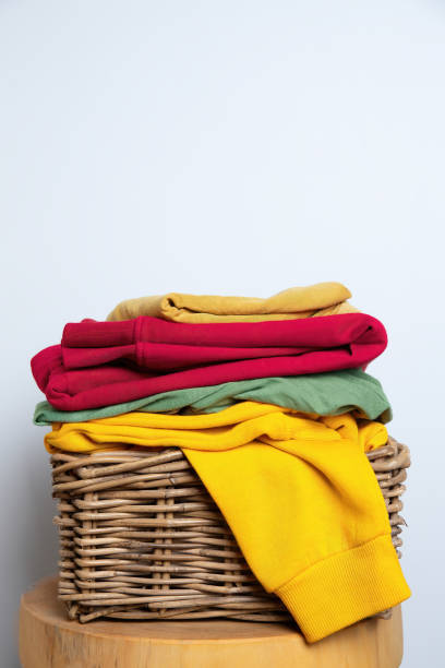 istock Stack of Colorful Clothes on Wicker Basket 2164232847