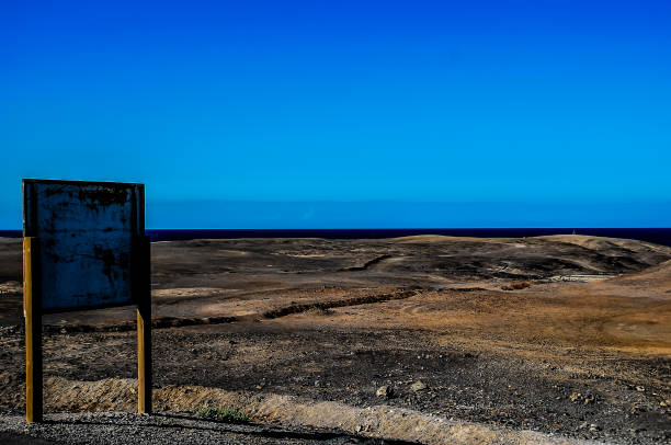 istock A sign is on a post in front of a large, empty field 2164234271
