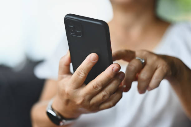 istock Close-up with a mature woman's hands using a smartphone 2164234817