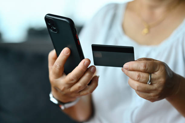 istock Close-up old woman's hands customer enters credit card code to pay online shopping, internet purchases, or payments via smartphone, Online banking concept 2164235207