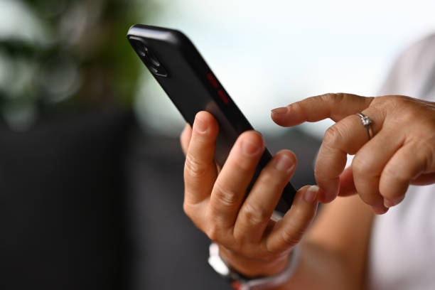 istock Close-up with a mature woman's hands using a smartphone 2164237562