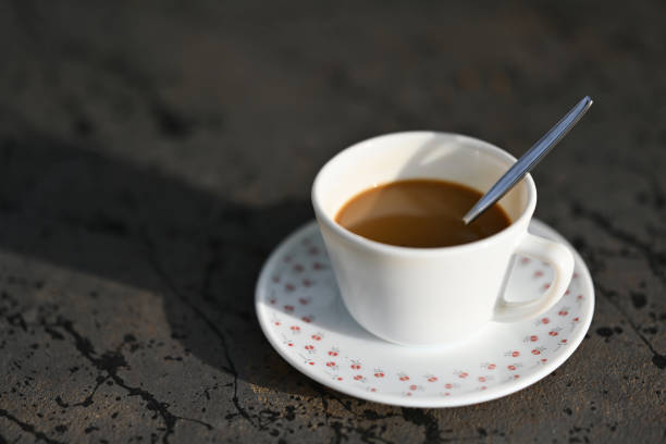 High angle view of a cup of freshly brewed aromatic cafe americano coffee served on cup over saucer