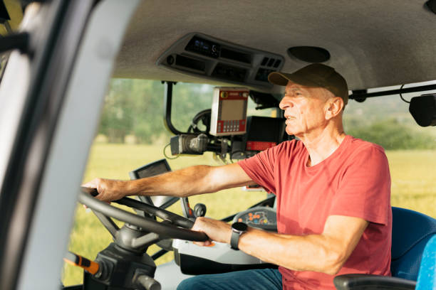 istock Senior farmer driving a tractor through the farm 2164242151