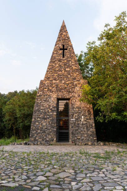 Catholic chapel in the middle of the forest at sunrise in summer.