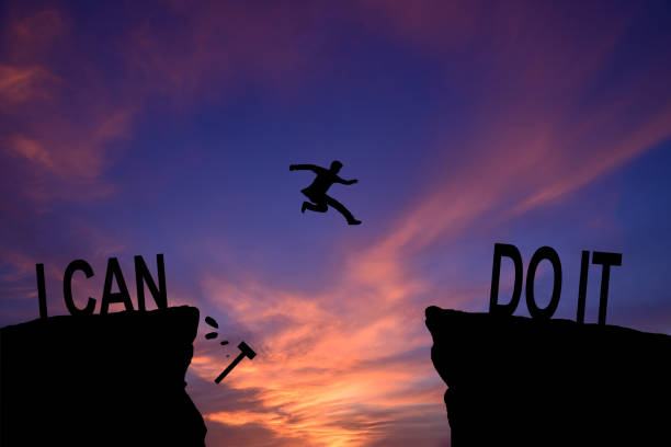 istock Man jumping on I can do it or I can't do it text over cliff on sunset background, Business concept idea 2164245737