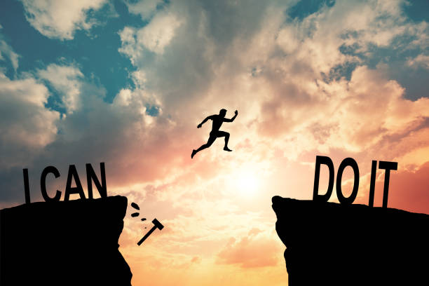 istock Man jumping on I can do it or I can't do it text over cliff on sunset background, Business concept idea 2164245827