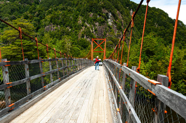 Simpson river National Reserve, Chile -  December 7, 2019: A man crosses  a bridge  over Simpson River in the Simpson river National Reserve,  southern Chile's Aysen Region.