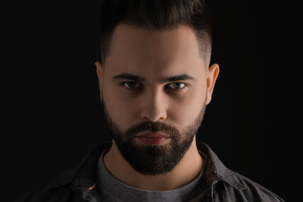 istock Evil eye. Man with scary eyes on black background 2164250587