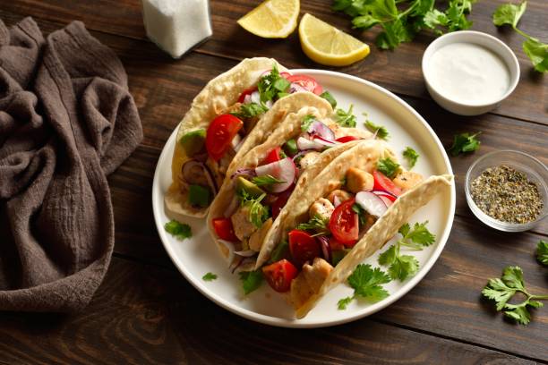 istock Tacos with vegetables and meat on wooden table 2164255087