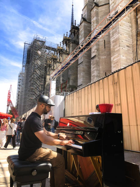 Barcelona. Spain - January 10, 2026: A street pianist plays a black grand piano in a busy pedestrian area while people walk by in the city center.