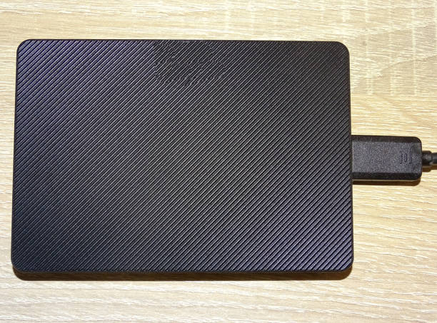 istock External hard drive with cable on a wooden background 2164258187