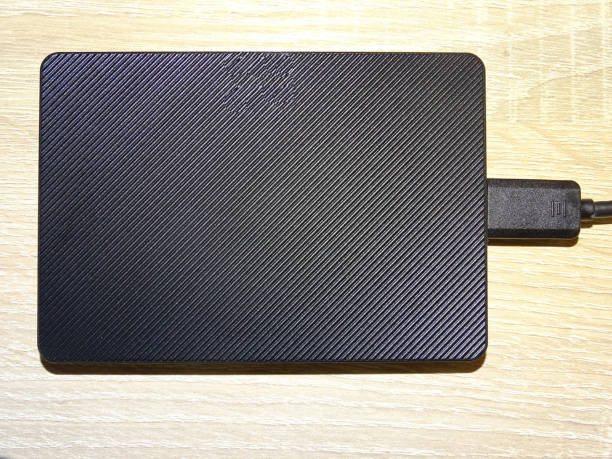 istock External hard drive with cable on a wooden background 2164258194