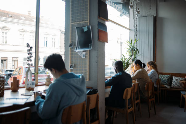 istock People Working and Socializing in a Cozy Cafe 2164260733