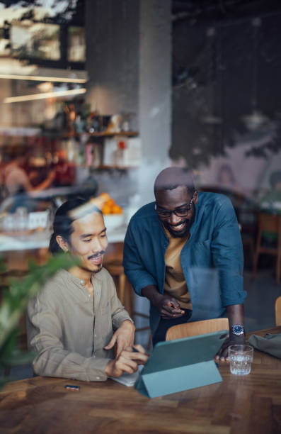 Two Men Collaborating on Digital Project in Cozy Cafe