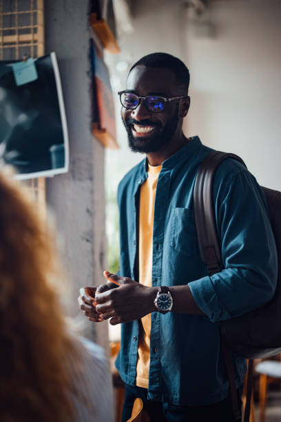 istock Smiling Man Socializing and Working in a Cozy Cafe 2164260785