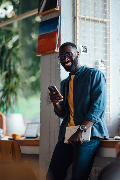 istock Smiling Man Working on Smartphone in Cozy Cafe 2164260793