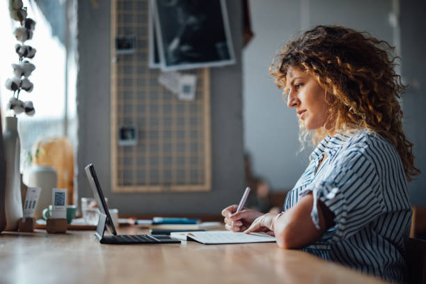 istock Woman Working on Laptop in a Cozy Cafe Setting 2164260805
