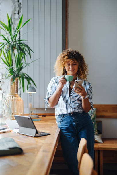 istock Woman Enjoying Coffee and Using Smartphone in Cafe 2164260835