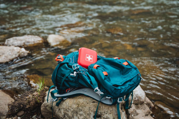 istock Electric blue backpack resting on a rock by the river in a natural landscape 2164260979