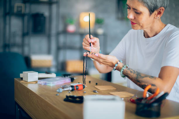 Senior woman making jewelry in a home workshop