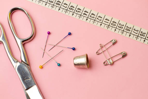 istock Scissors, sewing pins, thimble and sewing accessories on a pink background 2164265599
