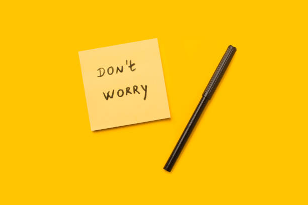 istock Dont worry short phrase write in a yellow adhesive paper and a black marker on a yellow background with copy space 2164265652