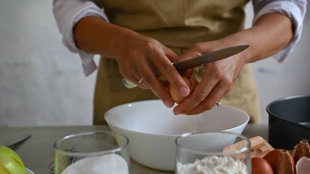 istock Hands cracking an egg over a bowl while preparing ingredients for homemade apple pie in the kitchen 2164266989