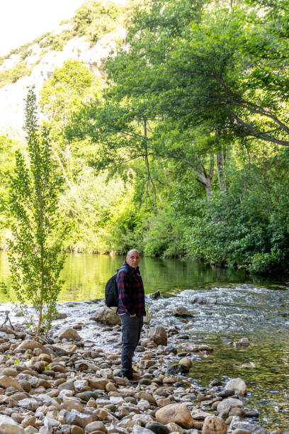 istock A tourist contemplates the scenery by a small river 2164267772