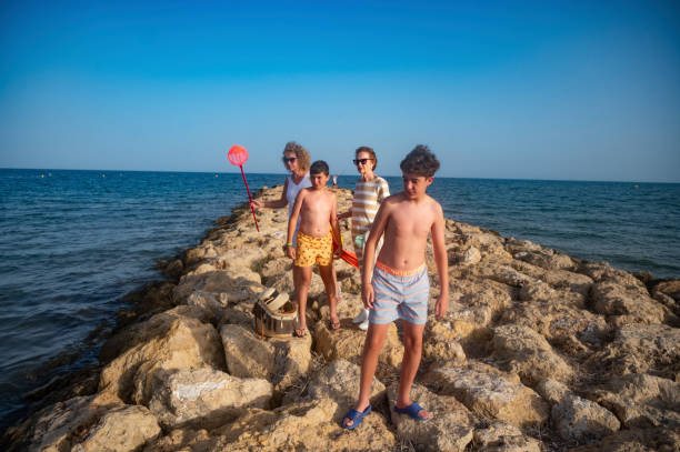 istock Family enjoying beach activities, exploring rocks andd searching for crabs 2164269492