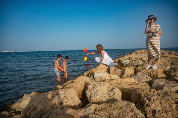 istock Three generation family playing and exploring on a rocky beach 2164269582
