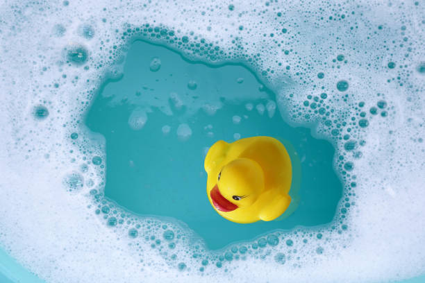 istock Yellow rubber duck in water with soap foam 2164272045