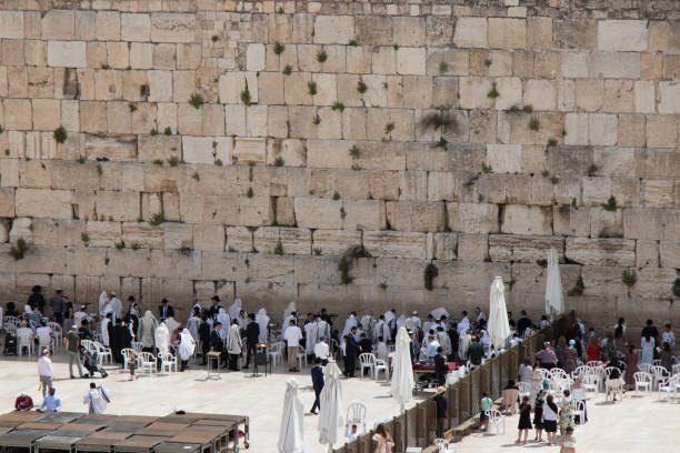 Western Wall - Wailing Wall or short 'the Kotel' and Dome of the Rock - Al-Aqsa Mosque (in the background) in Jerusalem. Crowd of Jews praying at the Western Wall - Wailing Wall - Klagemauer during the Passover Celebration Days. Wailing Wall - Western Wall, Jerusalem Old City, Israel, Middle East.