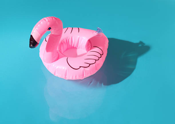 istock blue swimming pool, water texture, ripple surface, pink flamingo inflatable drink circle 2164273688