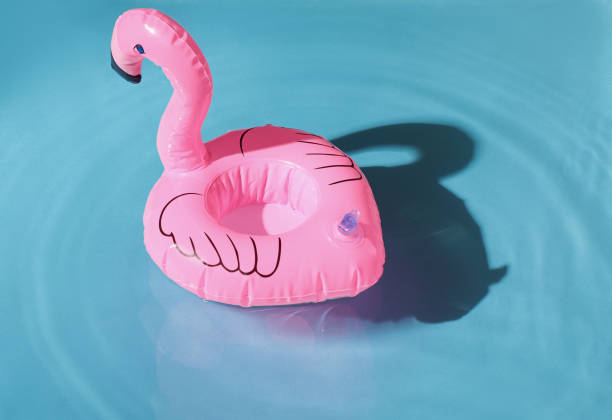 istock blue swimming pool, water texture, ripple surface, pink flamingo inflatable drink circle 2164273690