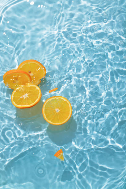 istock blue swimming pool, water texture, ripple surface and orange slices 2164273790