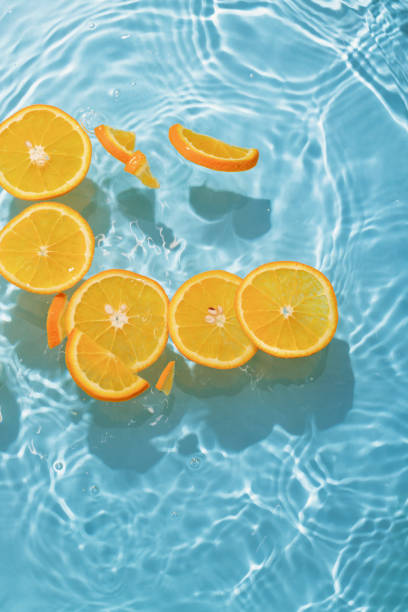 istock blue swimming pool, water texture, ripple surface and orange slices 2164273820