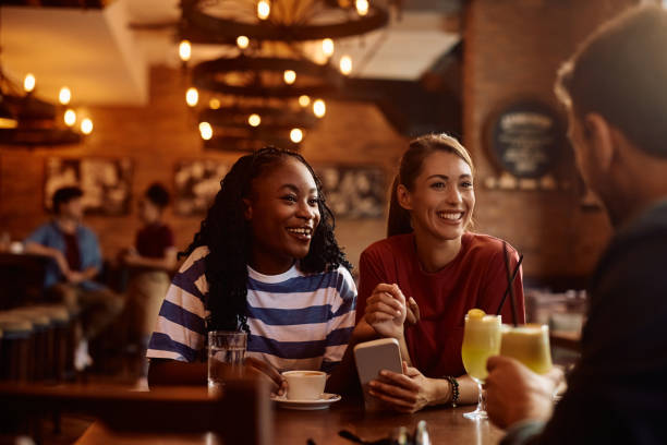 istock Happy friends talking while gathering in a cafe, 2164278808